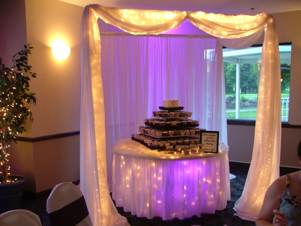 Illuminated wedding dessert table with purple ambient lighting